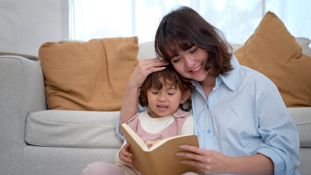 Mother reading a book with her child in a warm home setting