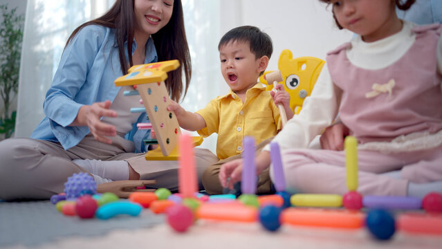 Teachers and parent playing joyfully with children, enhancing social and emotional development