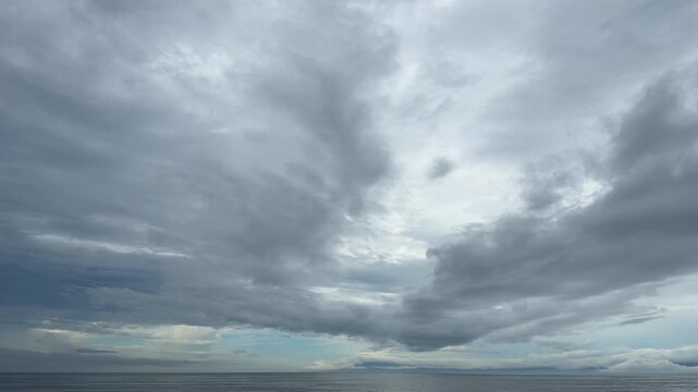 重厚な雲が広がる空と穏やかな水平線