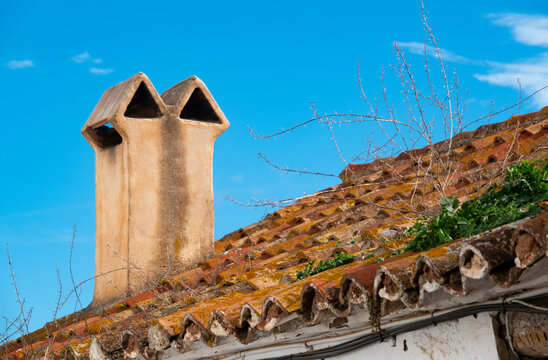 Traditional chimney and weathered tiled roof in Comares, M&aacute;laga, Spain