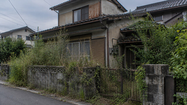 Abandoned Traditional Japanese House Overgrown with Vegetation