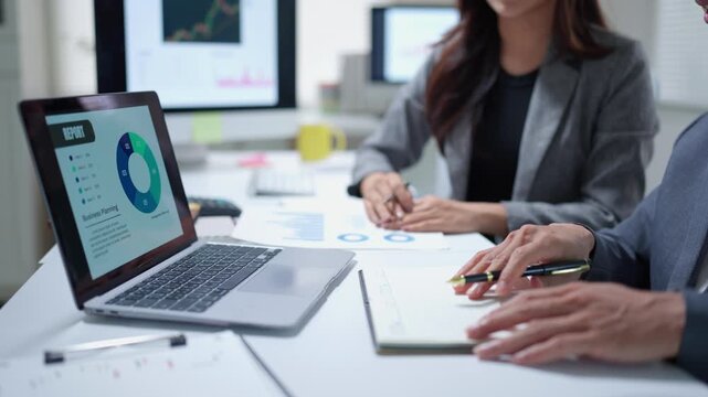 Business colleagues collaborating on a financial report and analyzing data charts during a corporate meeting in the office