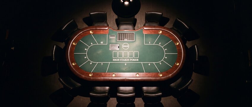 Overhead view of empty high stakes poker table with black leather chairs arranged around green felt surface for professional card games
