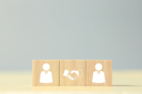 Wooden business people blocks with handshake icon represent partnership, agreement, teamwork, collaboration, negotiation, trust, networking, and successful business relationships. concept.