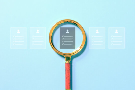 Magnifying glass highlights a candidate profile among applications, representing recruitment, resume screening, talent search, employee selection, hiring, and human resources. process.