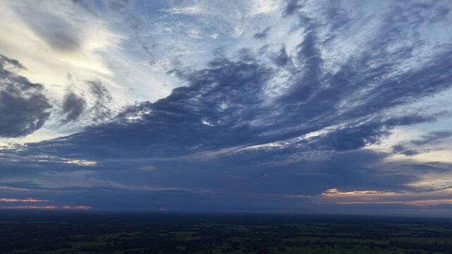 Dramatic sunset sky over rural landscape: moody storm clouds and golden hour horizon dramatic sky