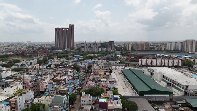 Drone shot featuring one of Chennai's tallest high-rise residential developments, with towering apartment buildings dominating the skyline above a large construction site.