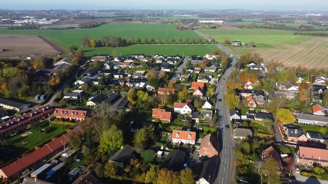 Gammel Ega village homes and road surrounded by farmland near Aarhus, Denmark, aerial
