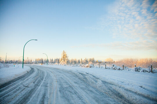 A curving snowy road on a cold winter morning