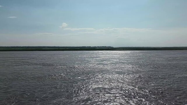 Wide river landscape with sun glare on water surface, serene natural background, for environmental and, travel projects