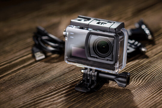 Action camera in waterproof case on wooden table.