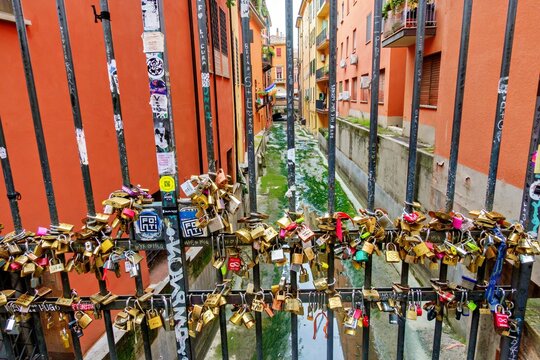 View of the Finestrella di Via Piella in Bologna, with a metal grate covered in love padlocks overlooking the Canale di Reno canal in Metropolitan City of Bologna, Emilia-Romagna, Italy.