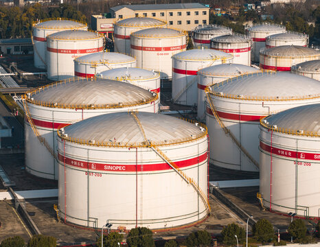 Aerial view of large white Sinopec oil storage tanks with red stripes. Industrial energy infrastructure and petroleum reserves facility. Wuhan, China, 21 Feb 2026