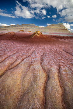 View of the colorful clay formations of Kyzyl Kup, known as Tiramisu, with red and white layers and eroded gullies under a blue sky in Karakiya District, Mangystau Region, Kazakhstan.