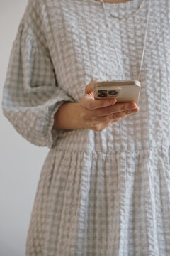 Woman Holding Smartphone in Casual Gray Dress