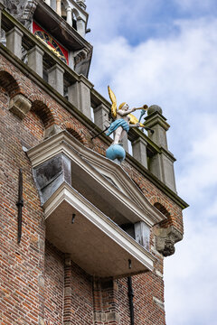 View of the golden angel statue blowing a trumpet on the historic brick church tower in Monnickendam, North Holland, Netherlands.