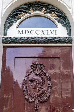 View of a historic wooden door featuring a relief of a helmeted figure and a fanlight with the Roman numeral date MDCCXLVI in Monnickendam, North Holland, Netherlands.