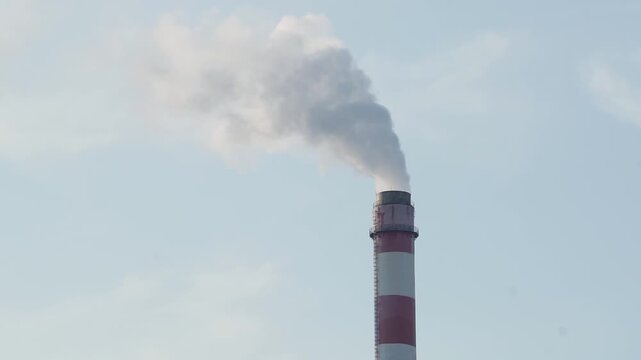 Tall chimneys of the power plant billowing thick smoke