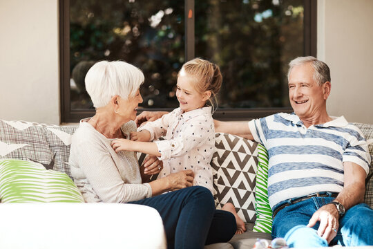 Relax, happy and grandparents on patio with child for bonding, love and babysitting on weekend. Family, house and girl with grandma, grandpa and laugh on sofa for relationship, connection and trust