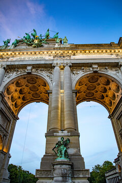 View of the Cinquantenaire Arch with its bronze quadriga sculpture, intricate stone carvings, and warm architectural lighting in Brussels, Brussels, Belgium.