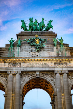 View of the Cinquantenaire Arch featuring its iconic bronze quadriga sculpture, intricate stone carvings, and golden coat of arms in Brussels, Brussels, Belgium.