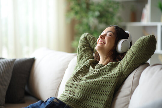Happy young woman relaxing listening digital audio from headphone