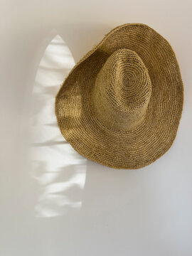 Woven straw sun hat hanging against a sunlit wall, Gers, Saint-Georges, France