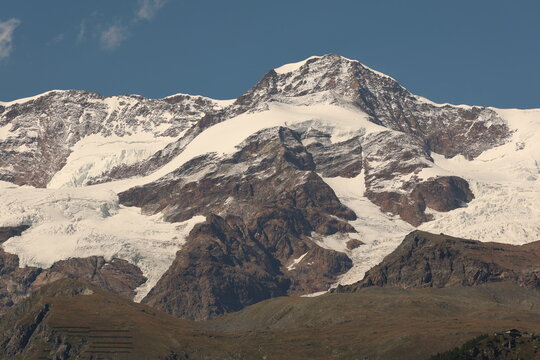 View of the Lyskamm mountain in the Monte Rosa massif, featuring dramatic glaciers and snow-covered peaks rising above the landscape in Gressoney-Saint-Jean, Aosta Valley, Italy.