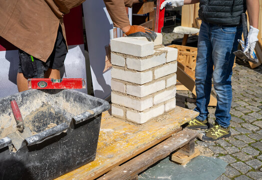 Bricklaying Apprentice Building a Wall During Exam in Germany