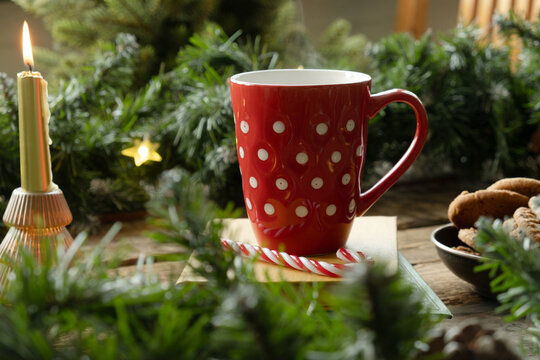 Christmas holidays. Mug of hot tea or coffee against background of Christmas interior. Cozy winter mood