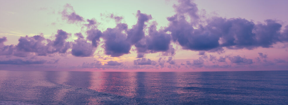Early morning on the beach. Pink-purple dawn over the sea. Pastel color