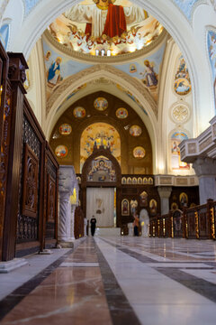 View of the interior of a Coptic Orthodox church with ornate wooden partitions, marble floors, and a vaulted ceiling decorated with religious murals in Cairo, Cairo Governorate, Egypt.