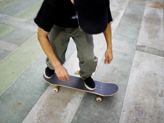 A male skateboarder with a black shirt doing a kickflip on a skateboard on a cloudy day in Thailand © Windscale
