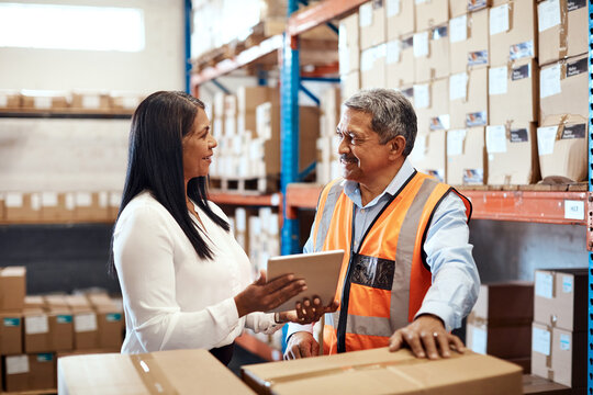 Team, tablet and discussion in warehouse for shipping, inventory audit or procurement feedback. Mature people, collaboration and tech for logistics box, stock check and happy with storage update