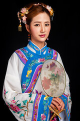 Fototapeta premium Elegant Young Woman in Traditional Qing Dynasty Chinese Embroidered Costume, Oriental Cultural Studio Portrait on Black Background
