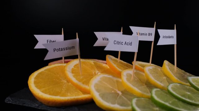 Assorted citrus slices turn on black slate with potassium, vitamin C, citric acid and antioxidant markers identifying their nutritional content. Healthy eating concept