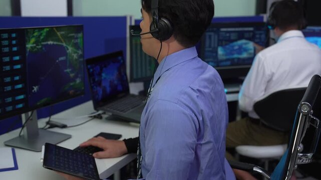 Air traffic controller monitors flight radar screens in a modern dark command center, aviation technology, flight safety, surveillance and precision.