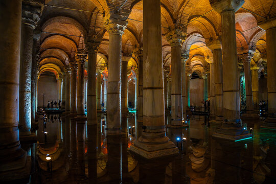 Architectural interior of the Basilica Cistern in Istanbul, featuring rows of columns and vaulted ceilings illuminated by warm lighting