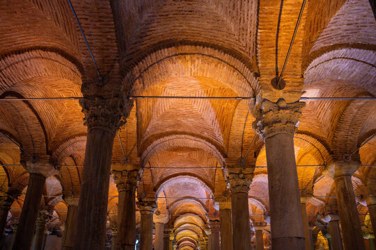 Architectural interior of the Basilica Cistern in Istanbul, featuring rows of columns and vaulted ceilings illuminated by warm lighting