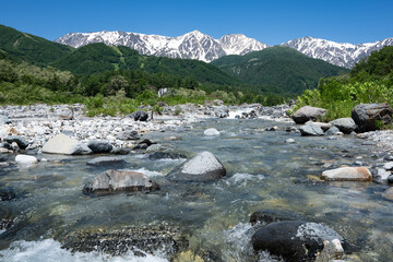 残雪の北アルプスと清流　長野県白馬村 © RATM