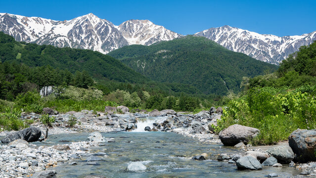 残雪の北アルプスと清流　長野県白馬村