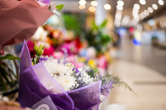 Pink roses and white flowers inside a bright shopping mall