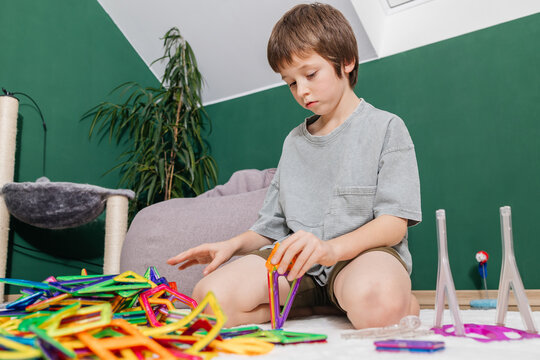 Boy playing with colorful magnetic construction tiles