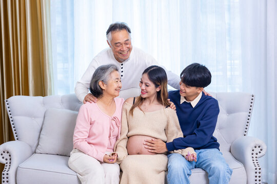 Heavily pregnant asian woman in her third trimester is enjoying her quality time at home with her supporting family and parent in relax and calm for maternity, motherhood, in law and extended family