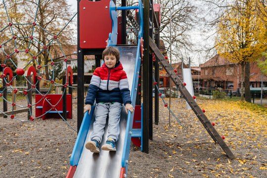 Young boy playing on slide at playground