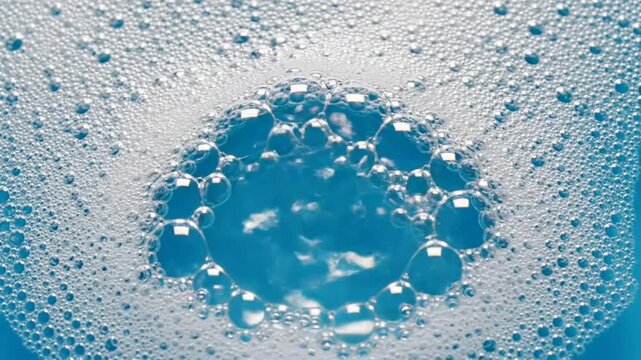 Close-up macro of soap bubbles expanding and popping in blue liquid, a relaxing and mesmerizing visual