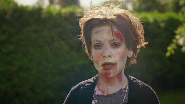 Portrait of Caucasian teenager wearing zombie makeup posing outdoors during Halloween celebration. Footage fits seasonal horror marketing, spooky event promos, and costume design advertising