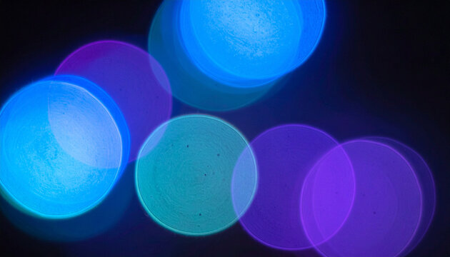 Vibrant blue magenta circular bokeh lights on dark black surface, soft blur glow leak with afterimage for compositing Generative AI
