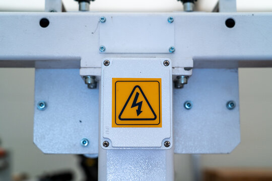 Yellow warning sign indicating high voltage danger on industrial equipment
