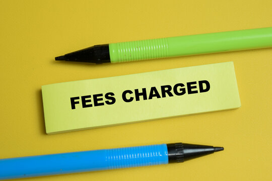 Concept of fees charged write on sticky notes isolated on table. For serving costs and banking charges